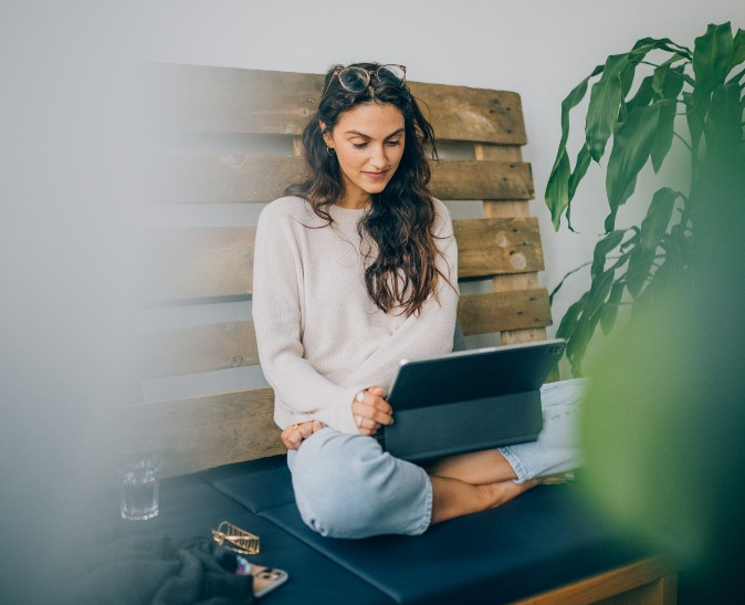 Patientin sitzt bequem vor ihrem Tablet währen der Online Psychotherapie