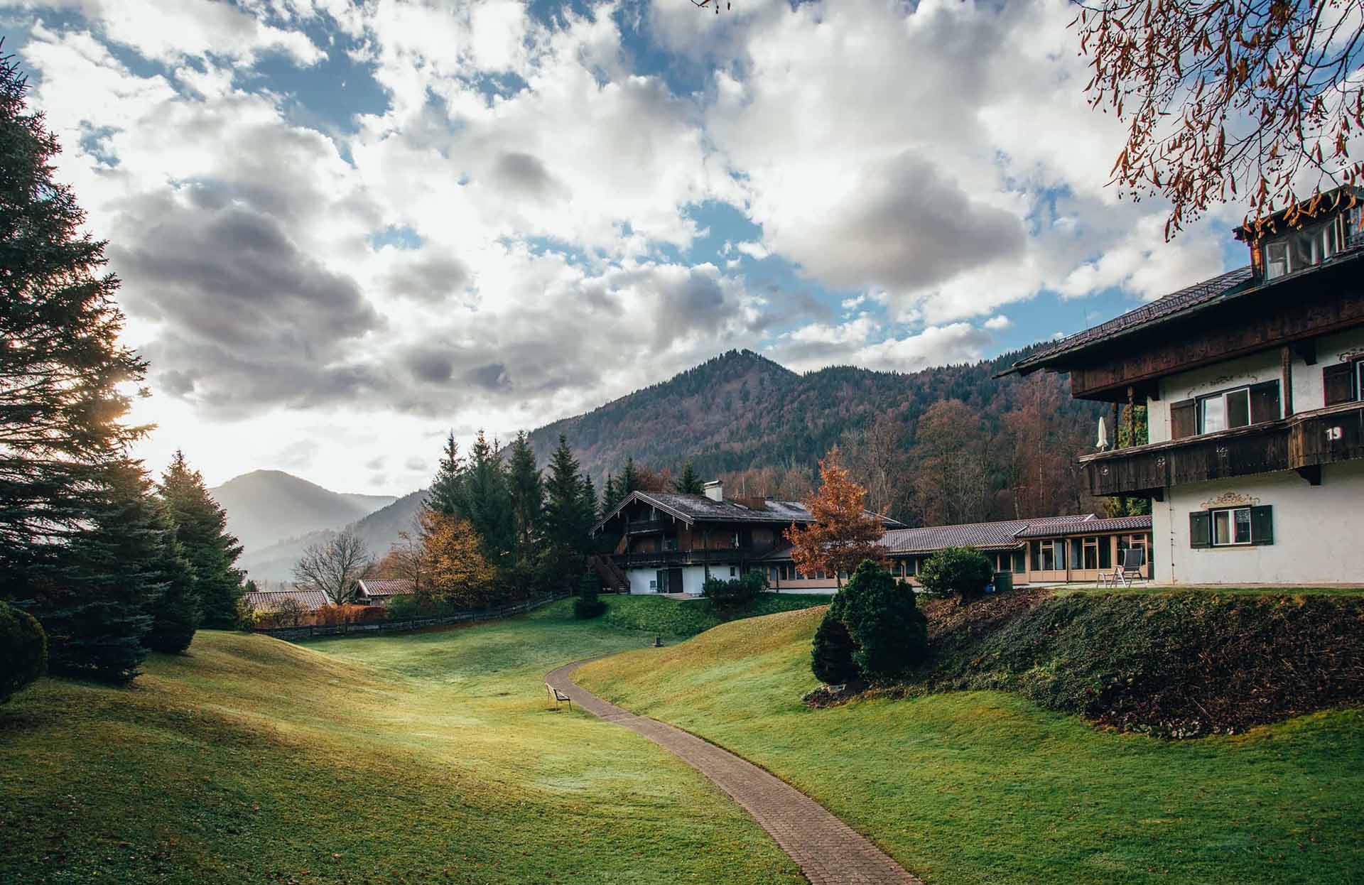 Außenansicht der KIRINUS Alpenpark Klinik mit Bergpanorama im Hintergrund.