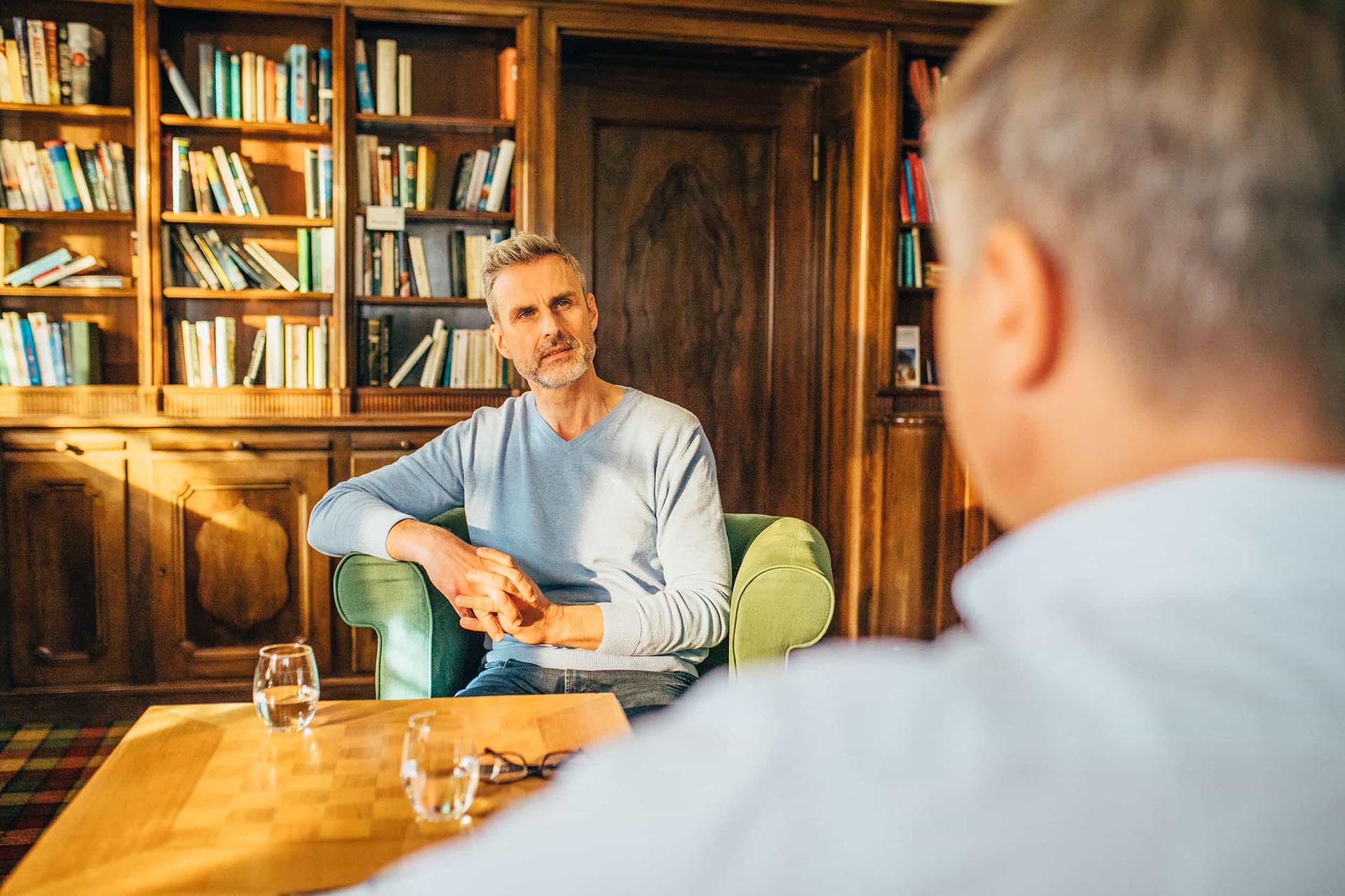 Gespräch zwischen zwei Männern in der Bibliothek